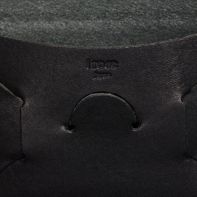 Detail of embossed irose company logo on black leather seamless card holder from Japan House London