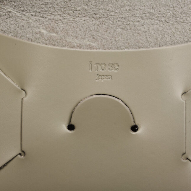 Detail of embossed irose company logo on grey leather seamless card holder from Japan House London