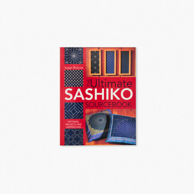 Book cover showing embroidered pillows and patterns made with white threads on indigo blue base using sashiko stitching technique.