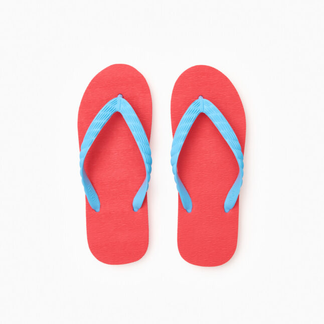Top view of a pair of red rubber flip-flops with light blue straps.