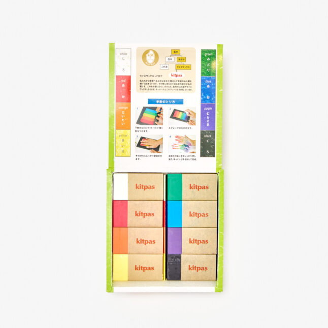 A box of 8 coloured, block-shaped crayons. The inner lid of the box shows a colour chart for each of the crayons.