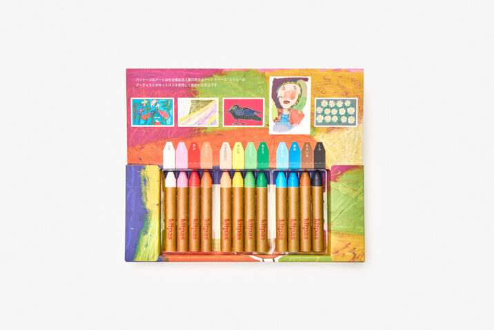 12 coloured crayons displayed in the box. The box features artworks made by people with learning disabilities using the crayons, and also shows the colours of each.