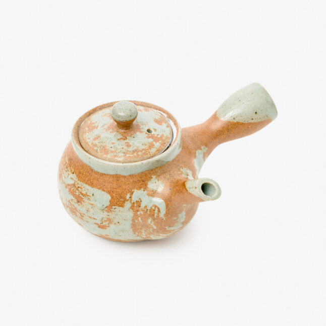a Japanese porcelain teapot with a mix of mint blue and copper-red colours on a white background