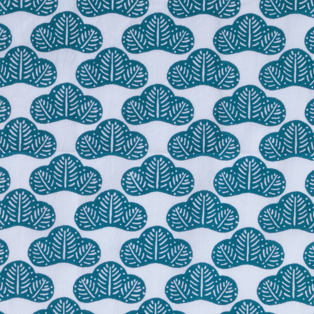 Close up of cotton fabric with green pine tree branches pattern