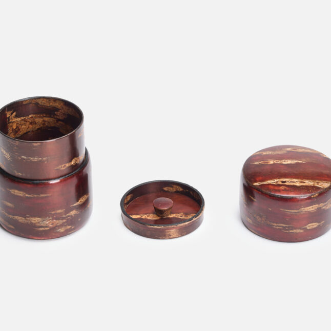 A sakura bark tea caddy with both the first and second lid placed next to it