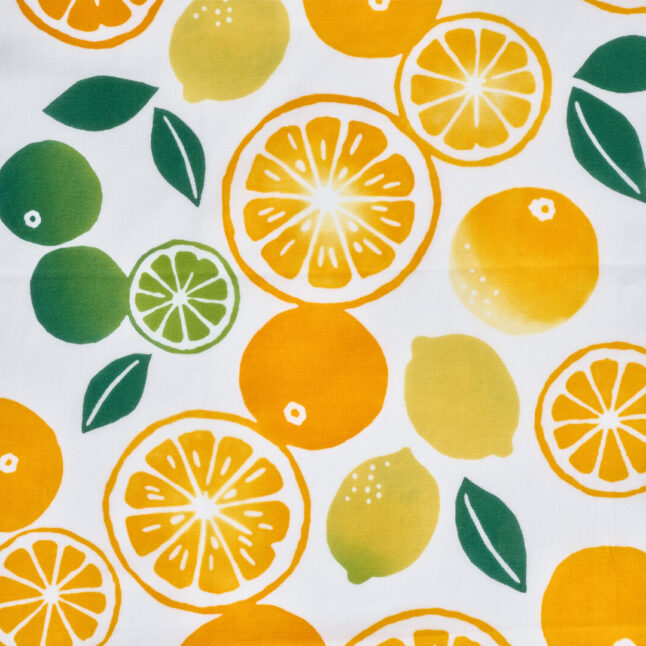 close up of a cotton cloth with a dyed pattern of citrus fruit in orange, yellow and green