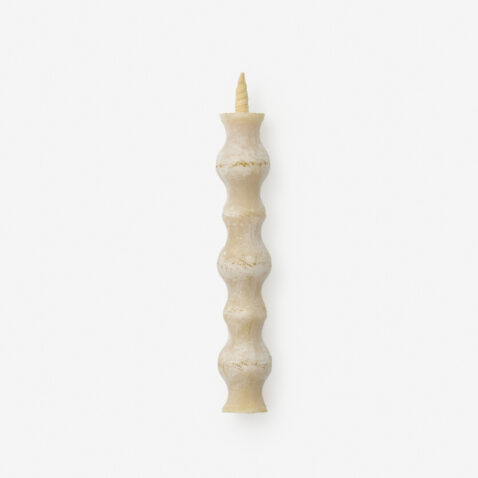A candle with a repetitive rippling pattern