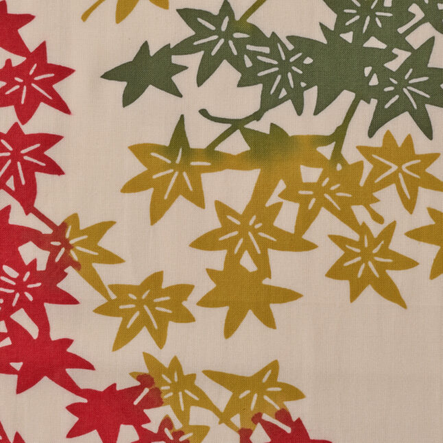 A close up of the tenugui hand towel with autumn leaves in red, yellow and green