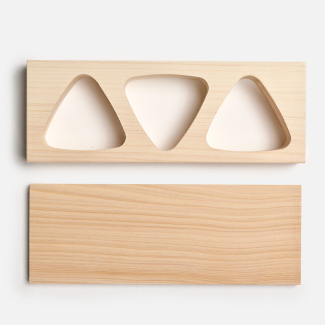 Onigiri mould with three onigiri shaped holes and a base