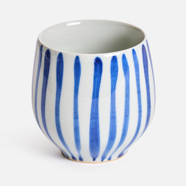 Striped pattern of a white base with gosu blue stripes on a rounded ceramic cup from Japan House London