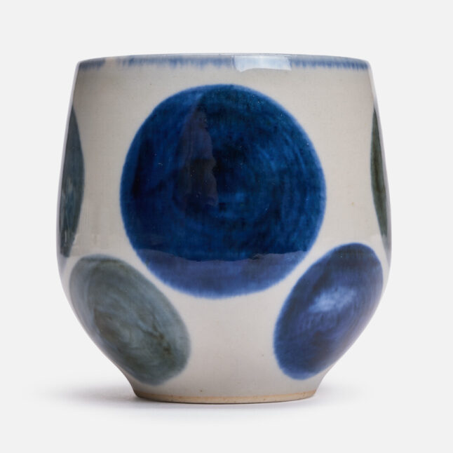 A rounded ceramic cup with a blue round pattern from Japan House London