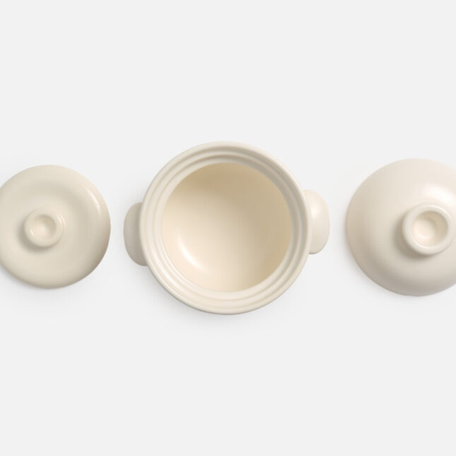 A small white Taiseigama rice pot with an outer lid and inner lid to the side from Japan House