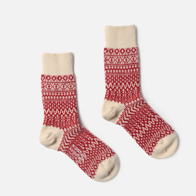 One pair of white and red wool jacquard socks shown side by side from Japan House London