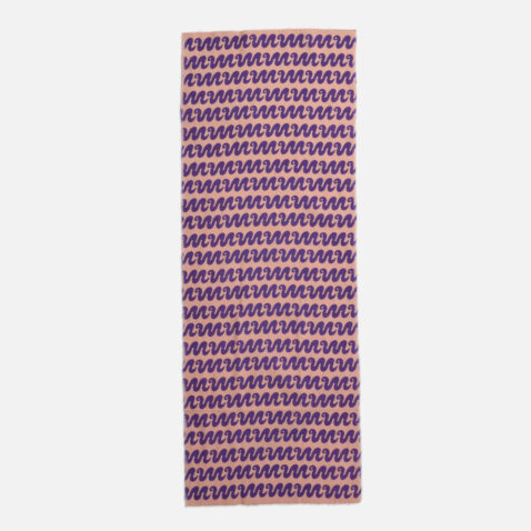 A pink cotton cloth with a repetitive pattern of purple snakes from Japan House London.