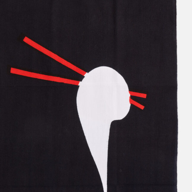 A cotton cloth with a piece of mochi being pulled with red chopsticks from Japan House London.