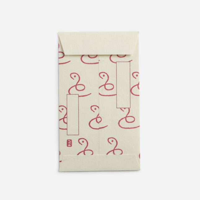 A small white envelope with a continuous pattern of a single line creating a snake from Japan House London.