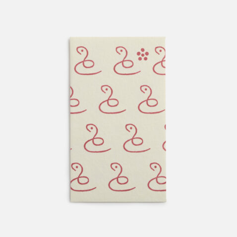 A small white envelope with a continuous pattern of a single line creating a snake from Japan House London.