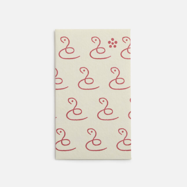 A small white envelope with a continuous pattern of a single line creating a snake from Japan House London.