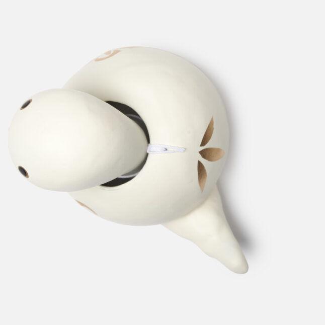 A figurine of a white paper snake with a bobbing head with gold and red markings from Japan House London.