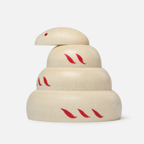 A light wood snake figurine with red markings from Japan House London.