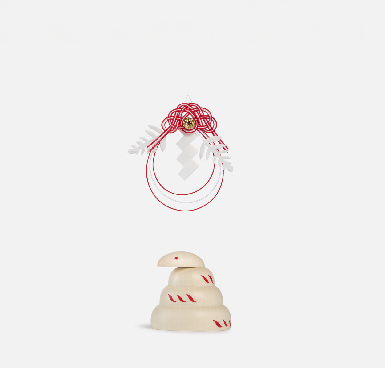 A red and white mizuhiki decoration placed above the wooden figurine of the snake