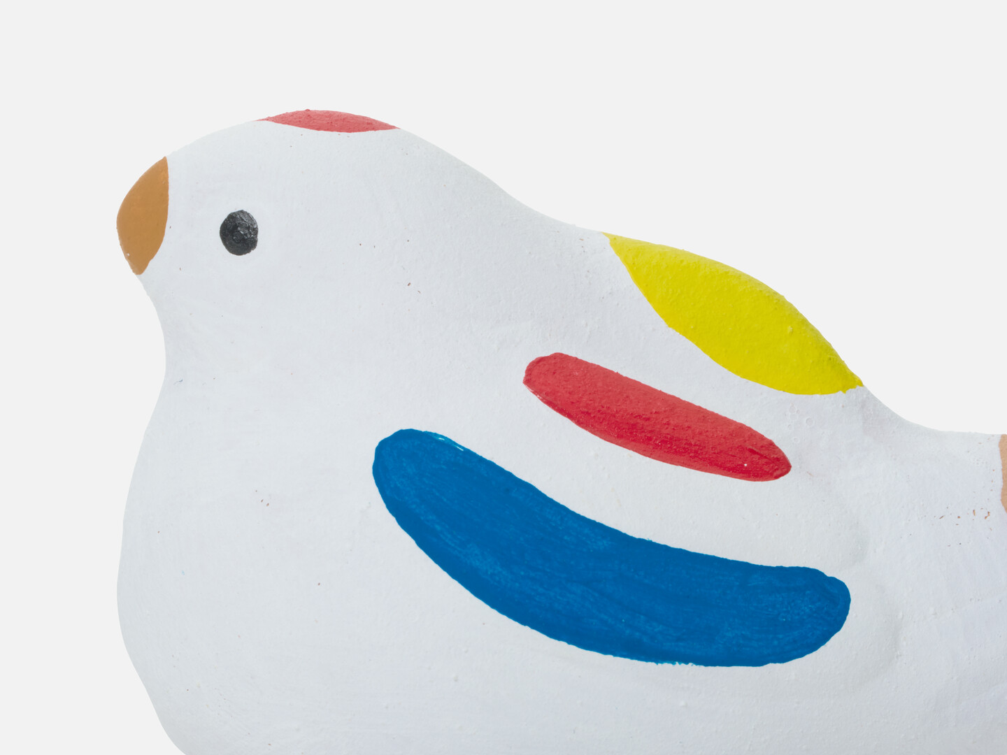 A figurine of a sparrow with a brown beak, blue, red and yellow marks on the wing and red mark on head from Japan House London.