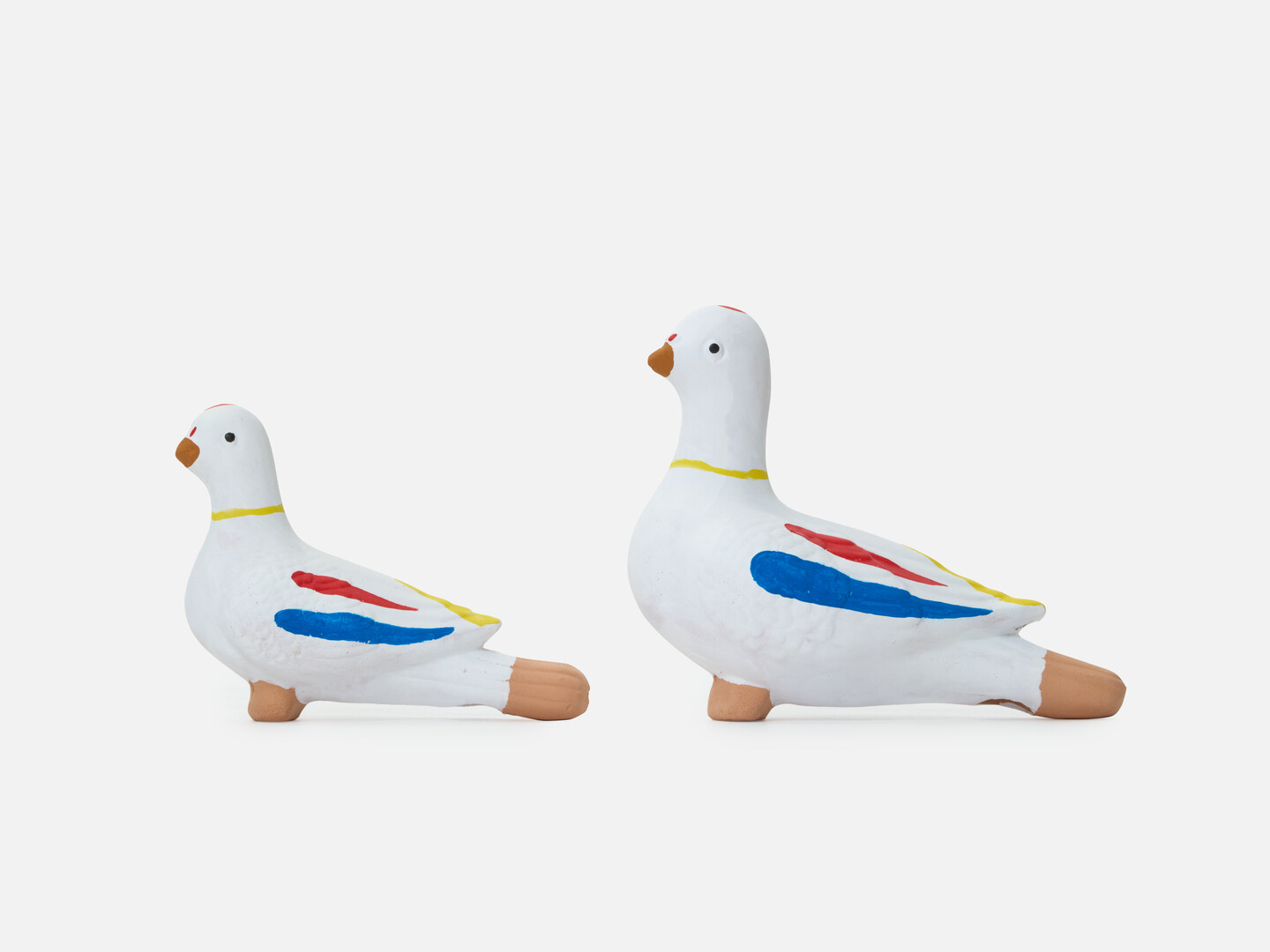 A medium sized dove figurine and a large sized dove figurine in a row from Japan House London.