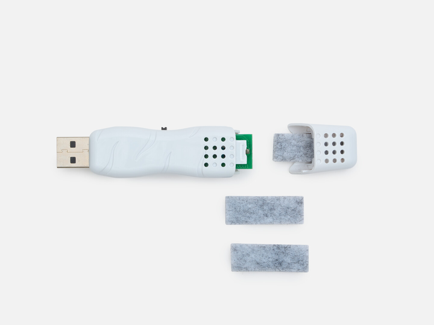 A white USB aroma with the cap off showing the felt pad to add aroma oil on and the two replacement felt pads