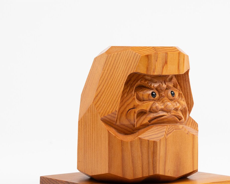 A hand carved wooden daruma