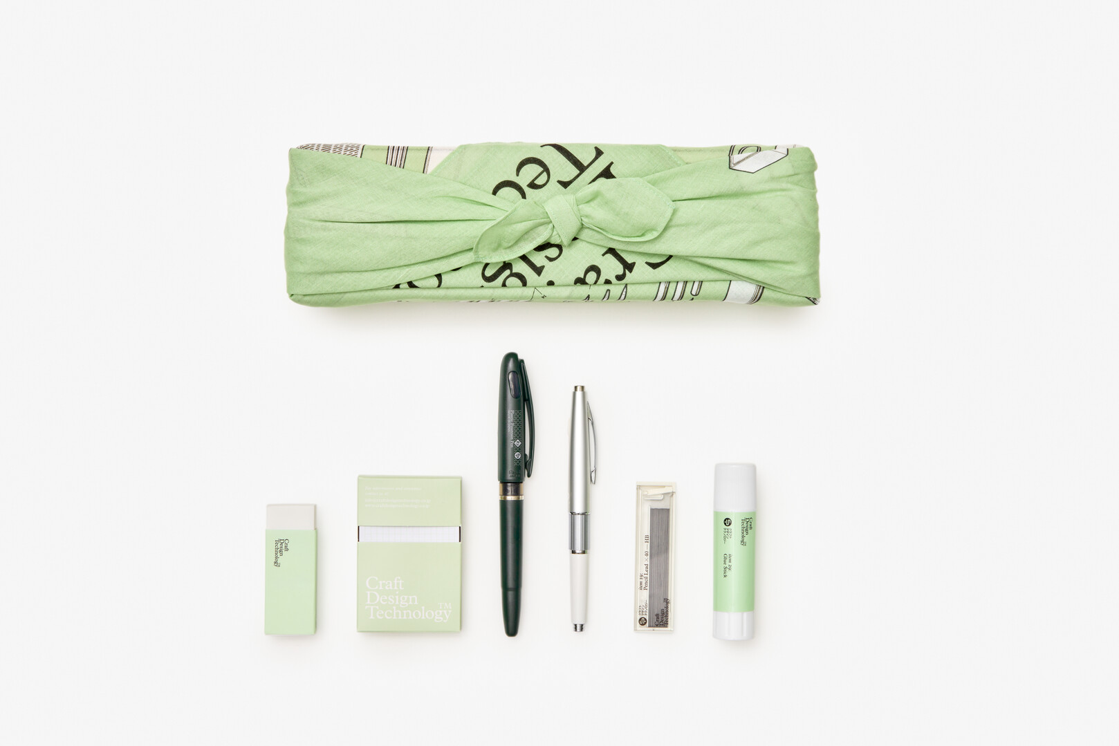 A stationery set with a rubber, post it note, fountain pen, mechanical pencil, pencil leads and glue stick
