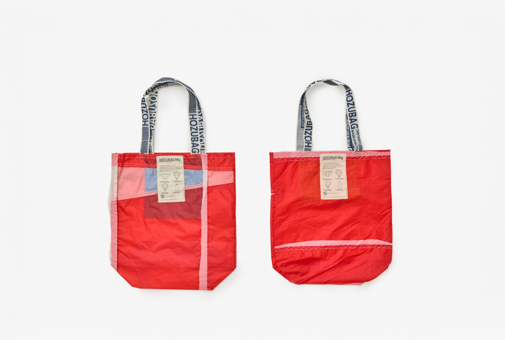 Two red semi translucent bags with handles of the words Hozu bag and labels reading Hozu Bag