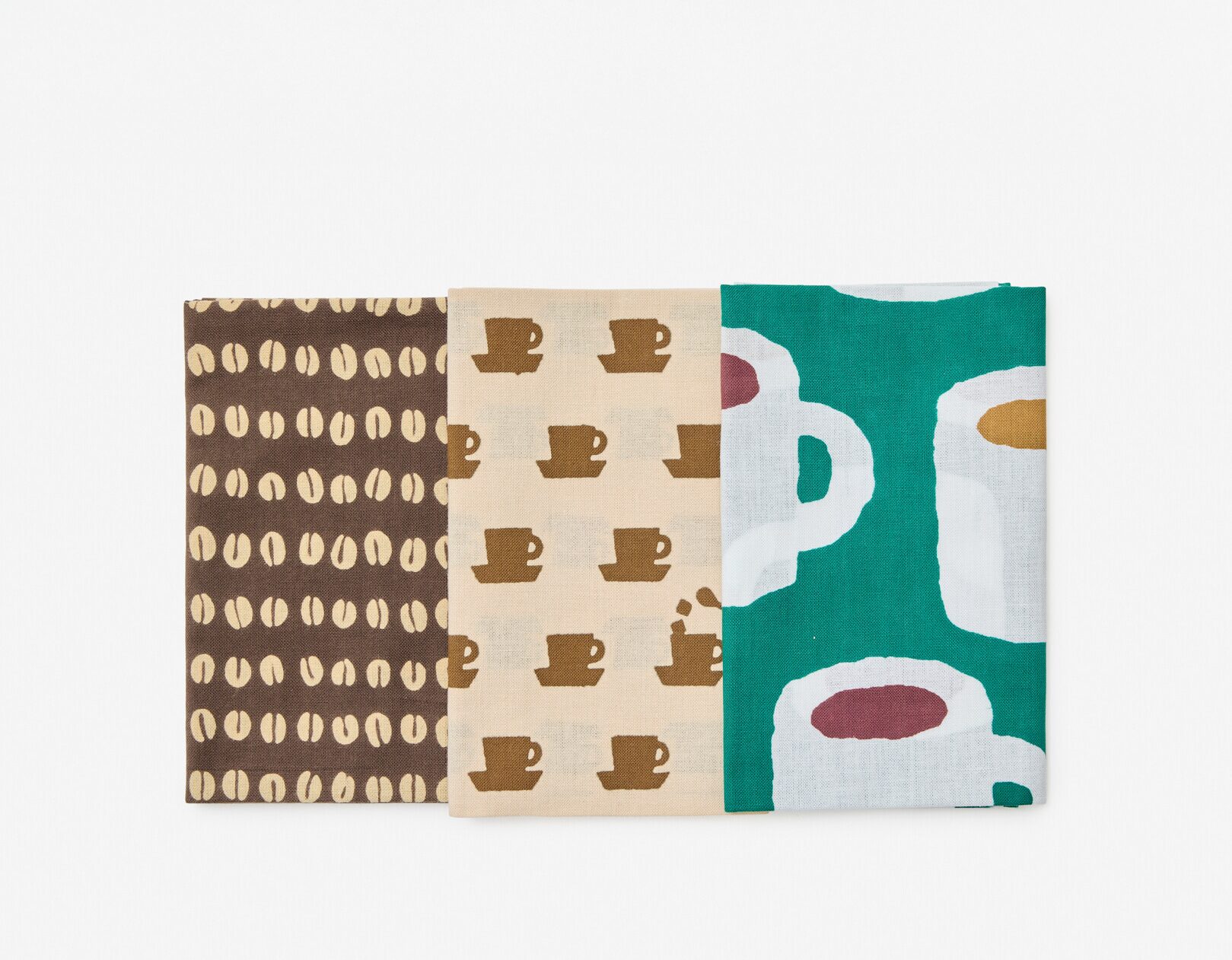 Three folded tenugui placed in a row, with one with a pattern of coffee mugs, another with coffee cups and the last with coffee beans