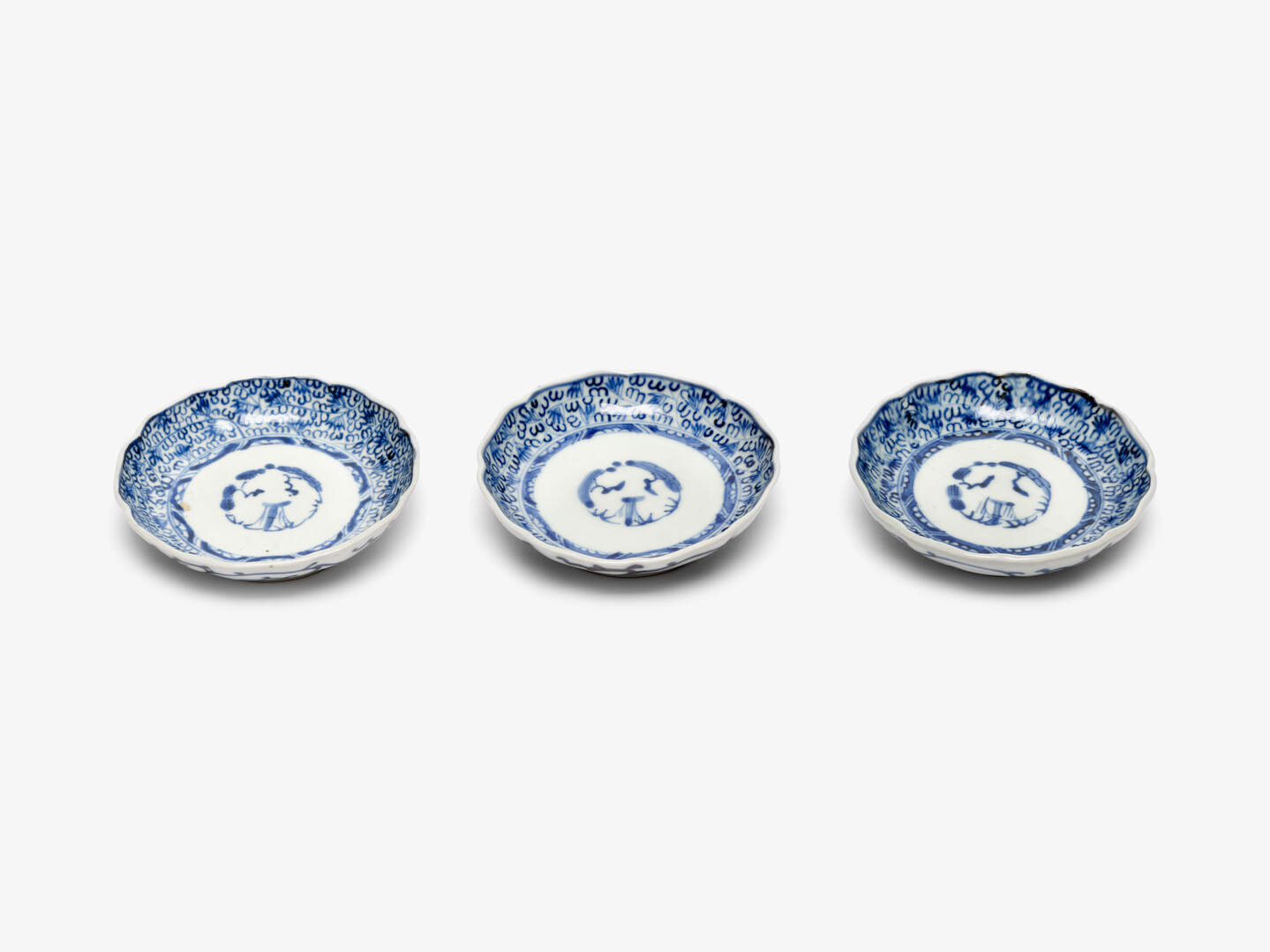 Three blue and white koimari plates in a row