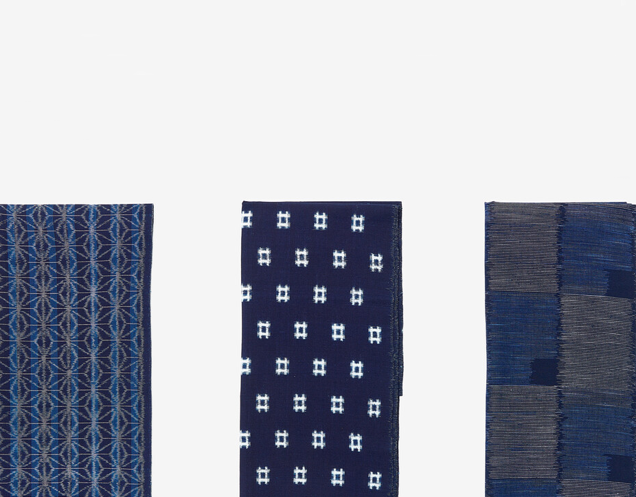 The lengths of indigo textiles one with a white star like pattern, another with a white square and another with a chequered pattern