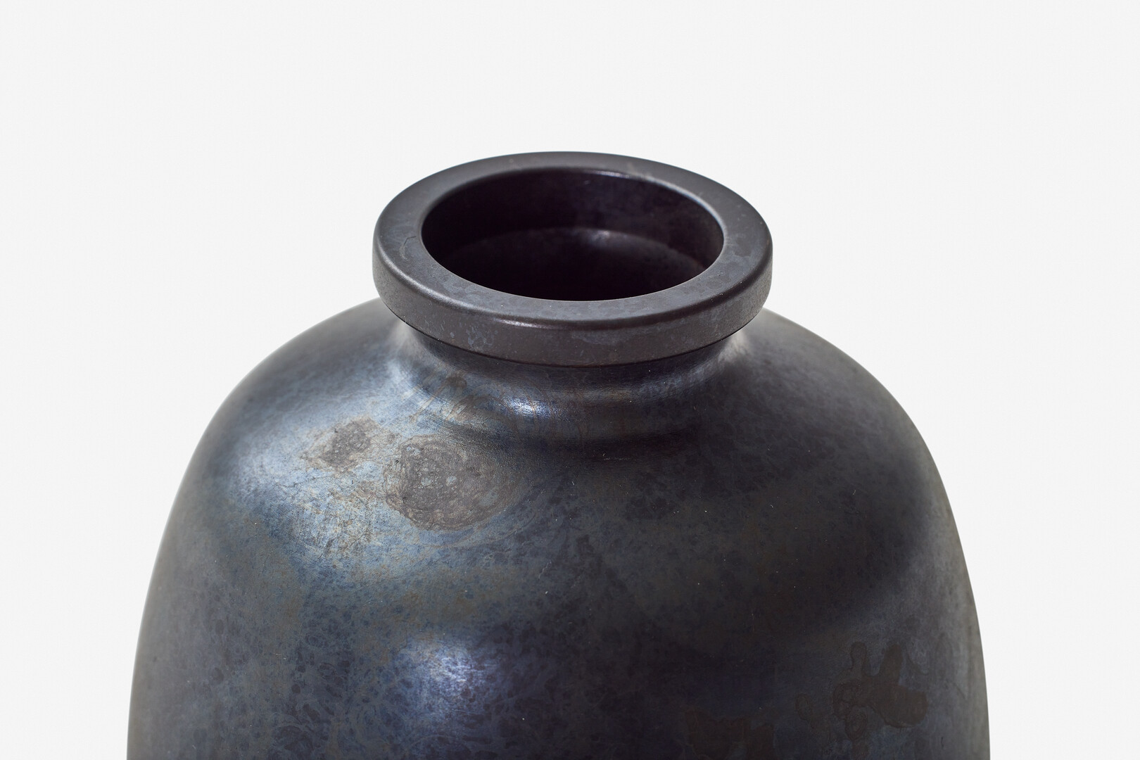 A black metal flower vase with a small opening