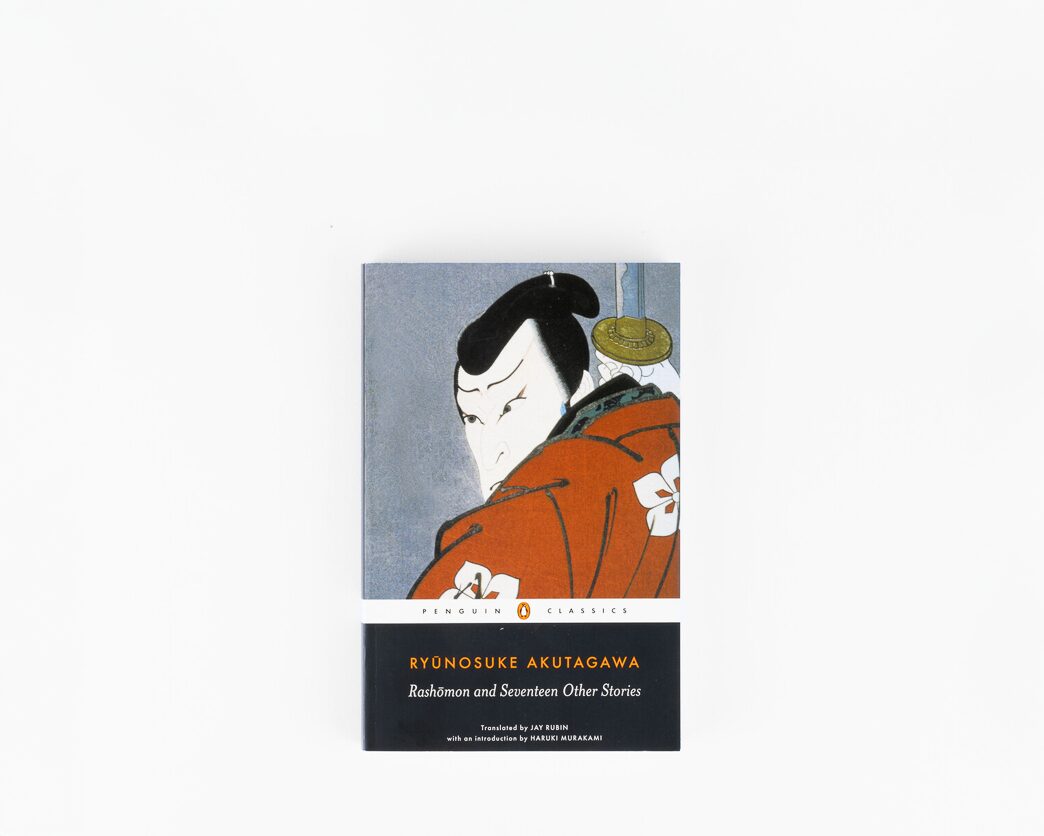 A book with an illustration of a man holding a sword and the words Ryunosuke Akutagawa Rashomon and seventeen other stories