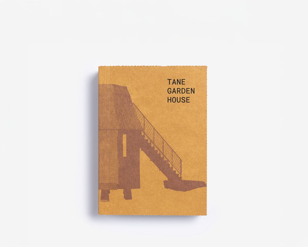 A small beige book with a dark outline of a house with the words Tane Garden House