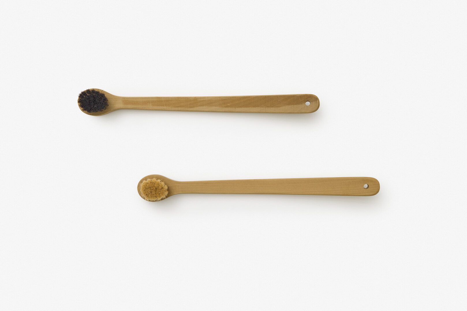 Two long handled body brushes, one with black bristles and another with beige bristles