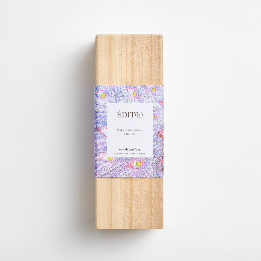 A rectangular wooden box with a label with purple peacock feathers and the EDIT(h) Nikko Jirushi Products since 1905 YUZUKI on the label in a wooden box