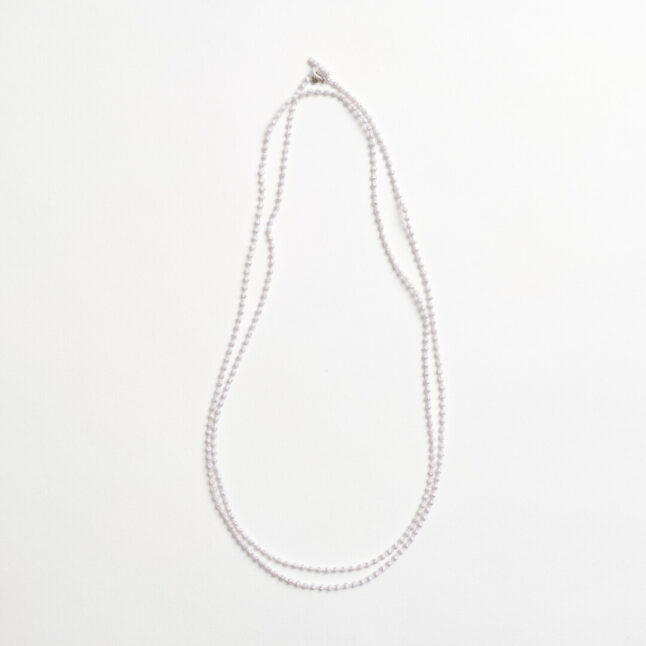 A silver textile necklace of a chain of small spheres