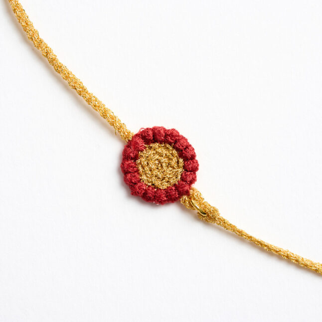 A gold textile chain with red flower