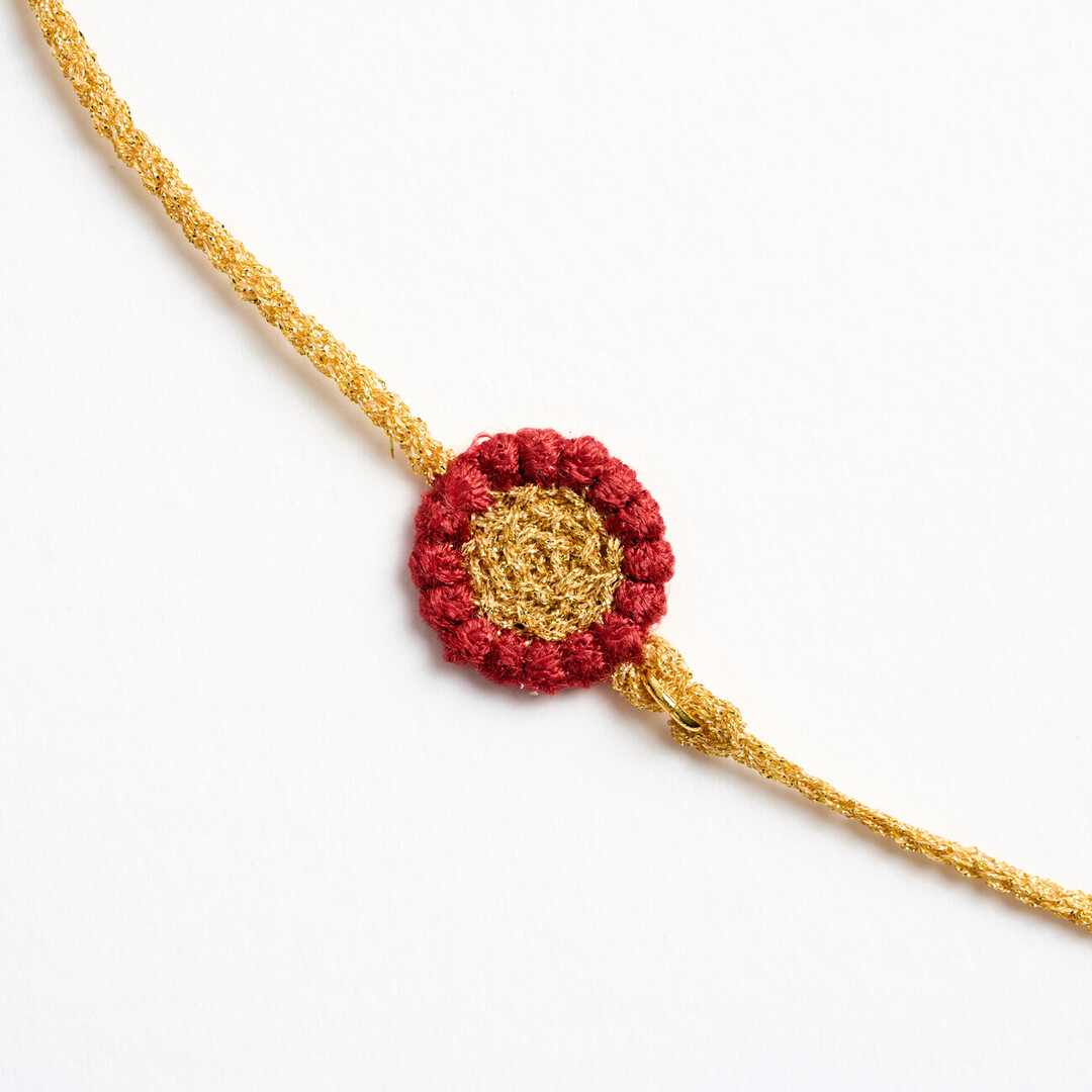 A gold textile chain with red flower