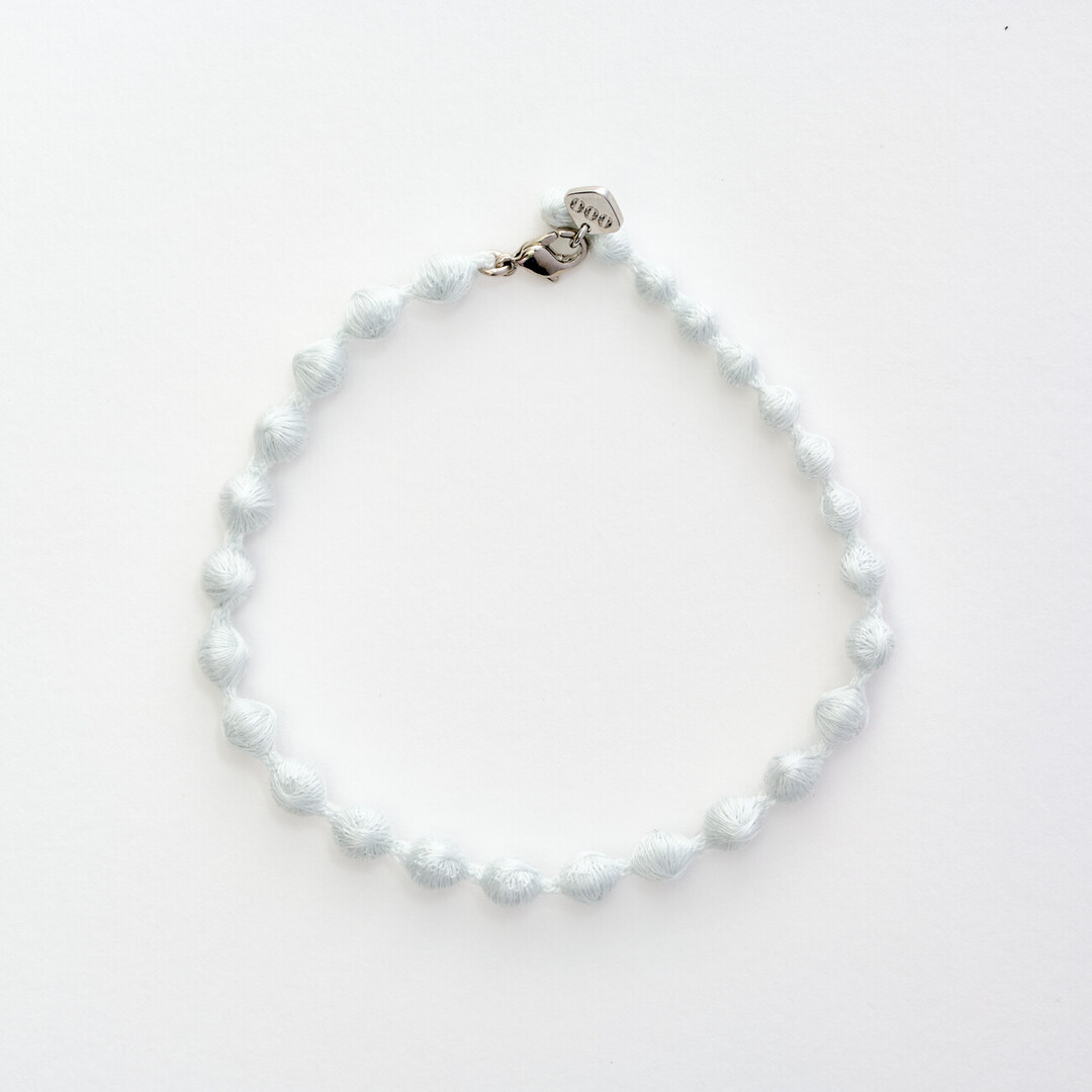 A light grey textile bracelet