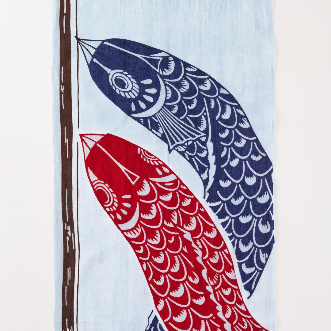 A light blue cotton cloth with a inflated dark blue carp windsock and a inflated red carp windsock hanging from a pole