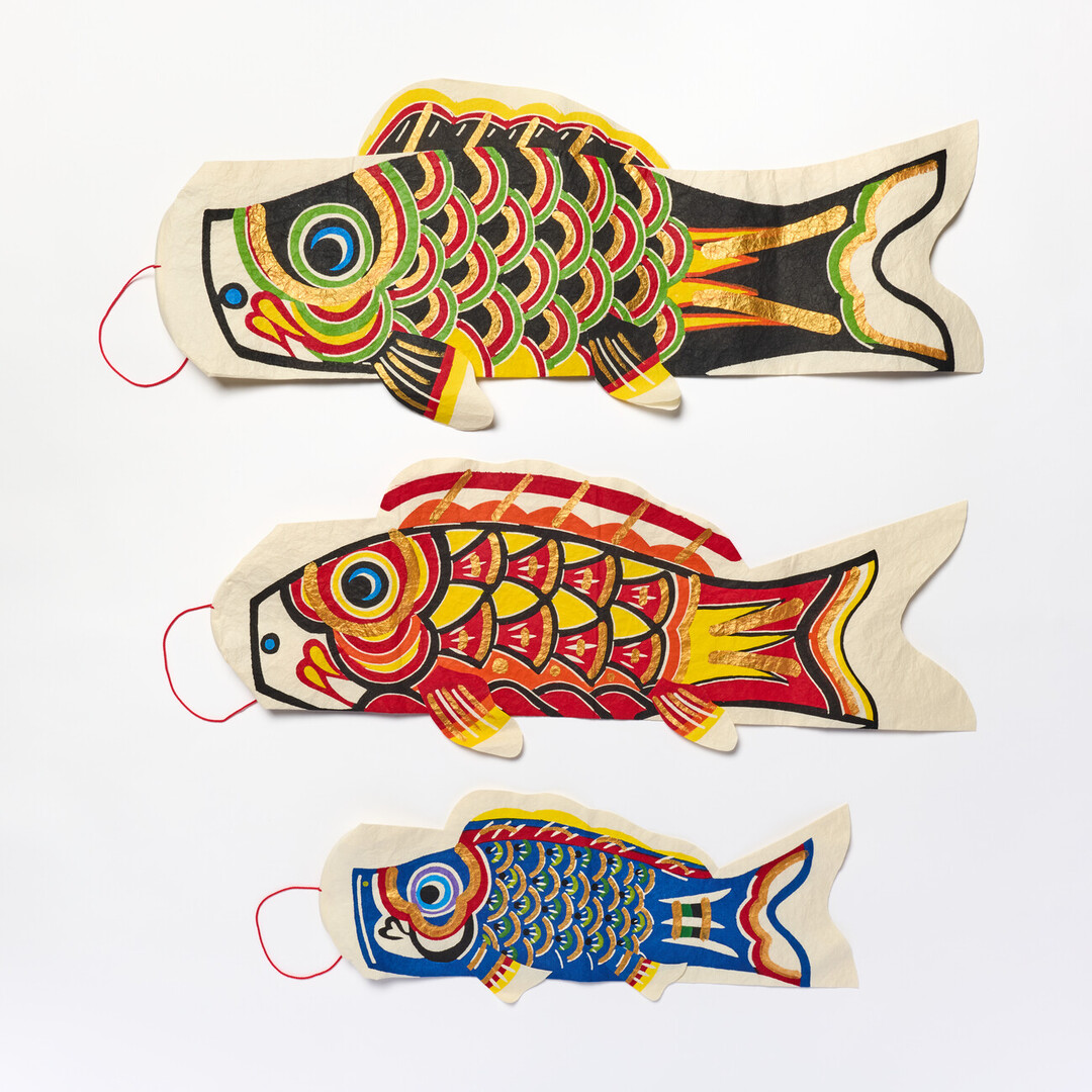 A large black washi koinobori above a medium red washi koinobori with a small blue koinobori below