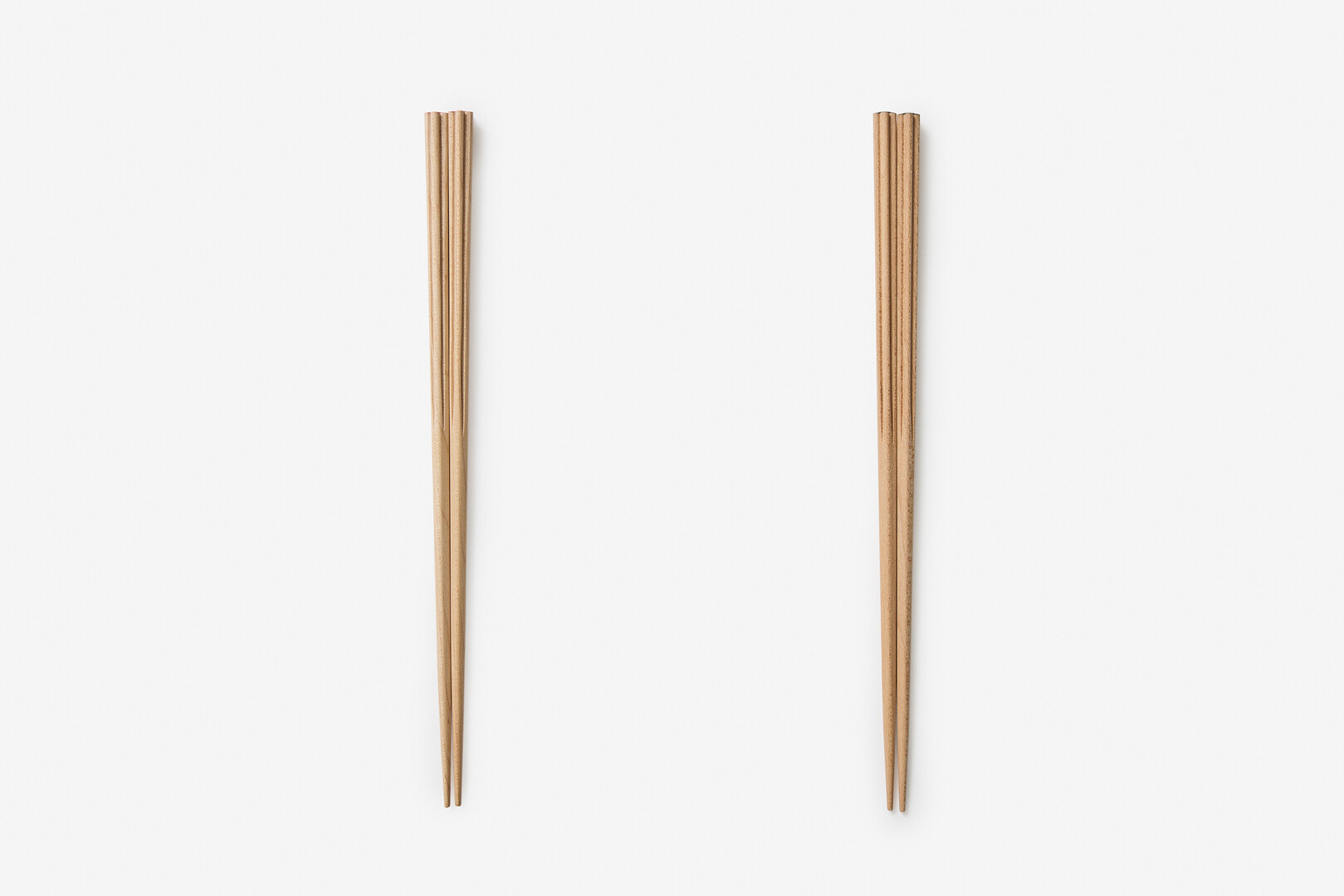 Two sets of chopsticks, one with a red lacquered top and another with brown lacquered top