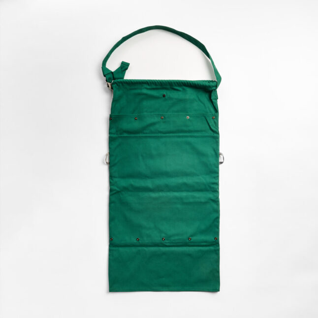 A green tote bag unfolded becoming an apron.
