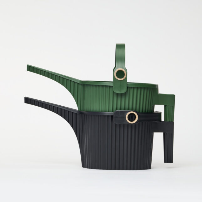 A green watering can stacked on top of a black watering can.