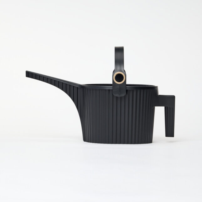 A black watering can with handle on the body and another arching over with a gold hole for the hose to fill with water.