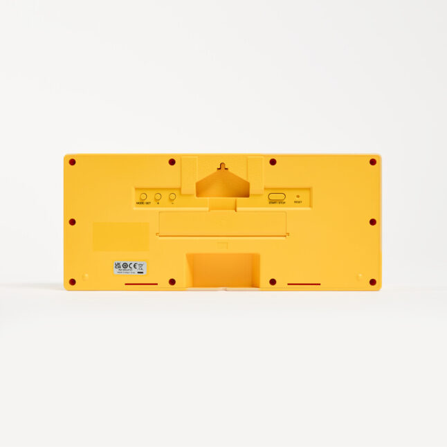Back of a yellow mantel clock showing a compartment for AA batteries